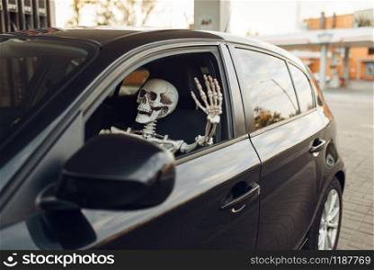 Human skeleton in car, fueling on gas station, fuel refill. Petrol, gasoline or diesel refuel service, petroleum refueling. Skeleton in car, fueling on gas station