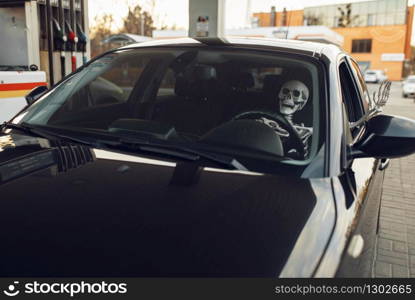 Human skeleton in car, fueling on gas station, fuel refill. Petrol, gasoline or diesel refuel service, petroleum refueling. Skeleton in car, fueling on gas station