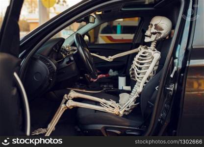 Human skeleton in car with opened door, fueling on gas station, fuel refill. Petrol, gasoline or diesel refuel service, petroleum refueling. Skeleton in car with opened door, gas station