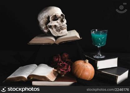 human skull with green drink books