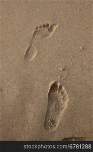 Human trace of a foot on yellow sand