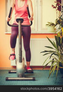 Human working out on exercise bike. Fitness.. Active human working out on exercise bike stationary bicycle. Sporty person training at home. Fitness and weight loss concept.