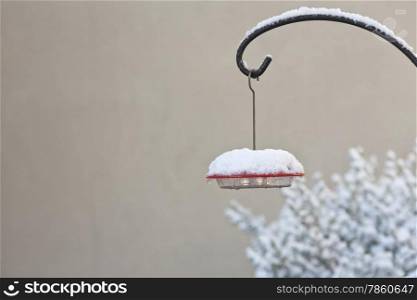 Hummingbird feeder is topped with a wintry covering of fresh ice and snow. Location is Tucson, Arizona, on New Year&rsquo;s Day, 2015. Unusual cold weather conditions in the Sonoran Desert of America&rsquo;s Southwest.