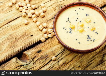 Hummus, a cold appetizer of chickpeas puree.Hummus on rustic wooden table. Hummus, chickpea puree