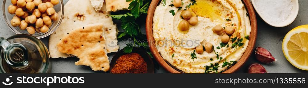 Hummus. Large bowl of homemade hummus garnished with chickpeas, red sweet pepper, parsley and olive oil, flat lay, middle east food, copy space