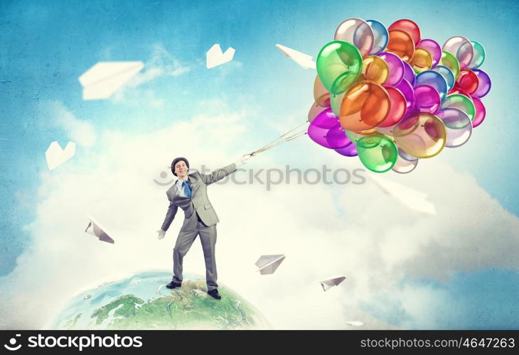 Humorous guy with balloons. Funny man in suit with bunch of colorful balloons in hand