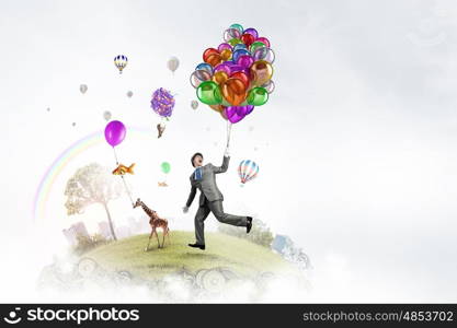 Humorous guy with balloons. Funny man in suit with bunch of colorful balloons in hand