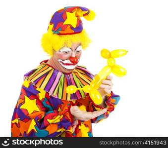 Humorous picture of a clown looking disgusted as a balloon animal poops in his hand.