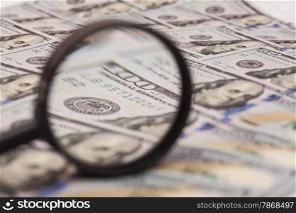 Hundred dollar banknote under magnifying glass