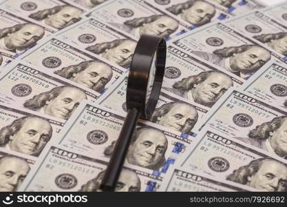 Hundred dollar banknote under magnifying glass