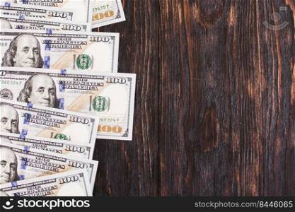 Hundred dollar bills on a wooden background. Blank space.. Hundred dollar bills on a wooden background. Blank space