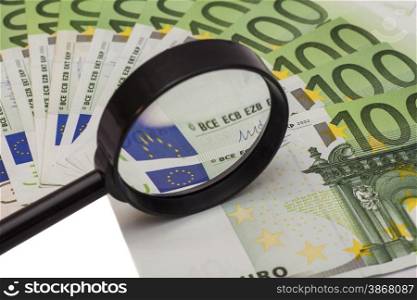Hundred euro banknote under magnifying glass