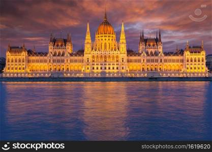 Hungarian Parliament Building along river Danube at dawn with colorful clouds sky. Sunset view Parliament Building along river Danube