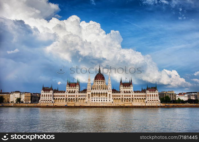 Hungarian Parliament Building by the Danube river in Budapest, Hungary and dramatic sky above.