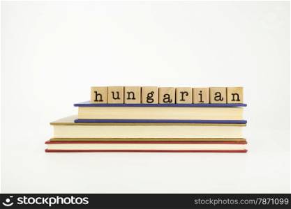 hungarian word on wood stamps stack on books, language and conversation concept