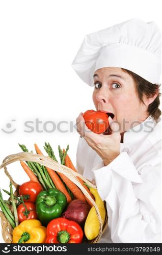 Hungry chef bites into a fresh ripe tomato. White background.