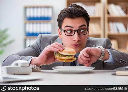 Hungry funny businessman eating junk food sandwich