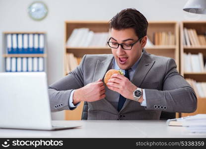 Hungry funny businessman eating junk food sandwich