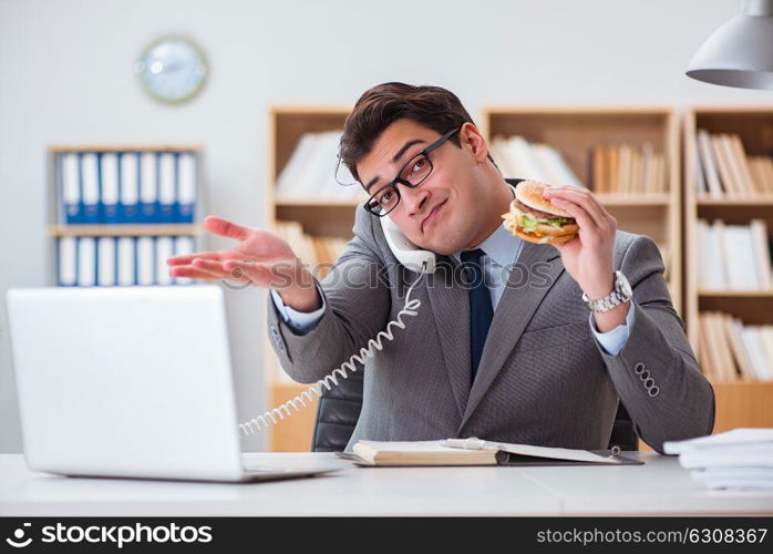 Hungry funny businessman eating junk food sandwich