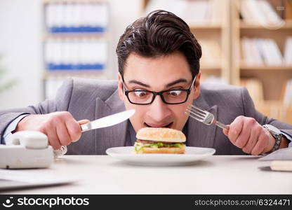 Hungry funny businessman eating junk food sandwich