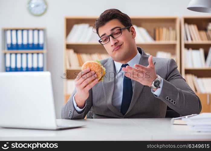 Hungry funny businessman eating junk food sandwich