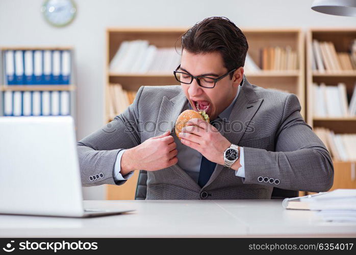 Hungry funny businessman eating junk food sandwich