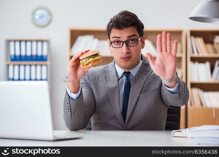 Hungry funny businessman eating junk food sandwich