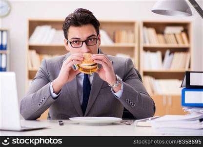 Hungry funny businessman eating junk food sandwich