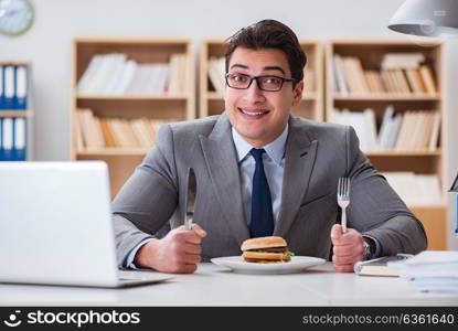 Hungry funny businessman eating junk food sandwich