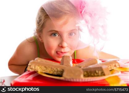 Hungry gesture blond kid girl in party with chocolates at birthday
