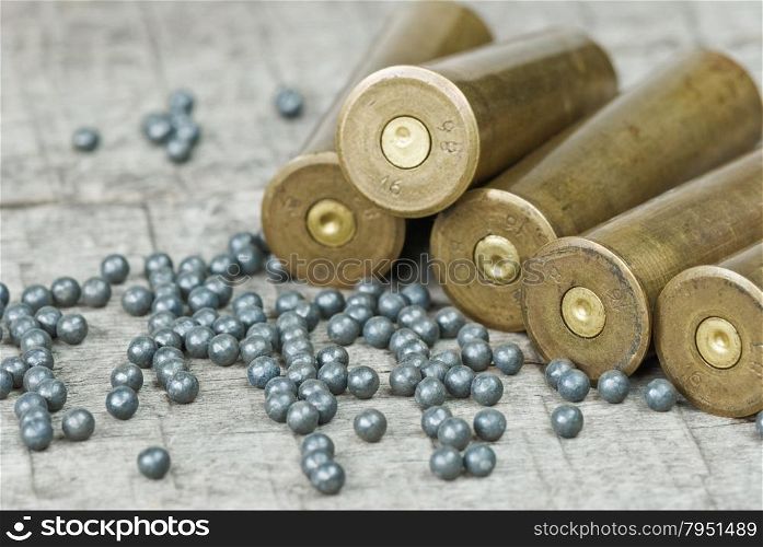 Hunting cartridges and lead shot on the background of old wooden boards