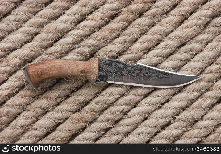 hunting knife on the background of hemp rope