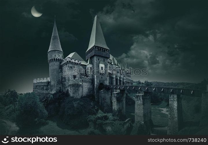 Hunyad Castle - Corvin's Castle in Hunedoarain Medieval european castle in a cloudy l moon night Romania.
