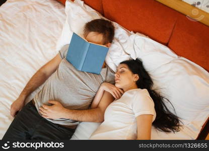 Husband and his pregnant wife with belly are sleeping in bed at home, bedroom interior on background. Pregnancy, prenatal period. Expectant mom and dad are resting on sofa, health care. Husband and pregnant wife with belly are sleeping