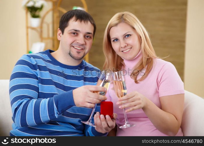 husband and wife celebrating something at home with glasses of chamagne