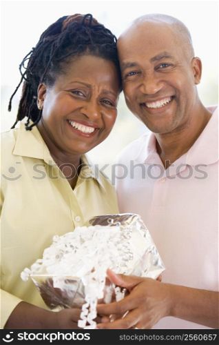 Husband and wife holding gift smiling