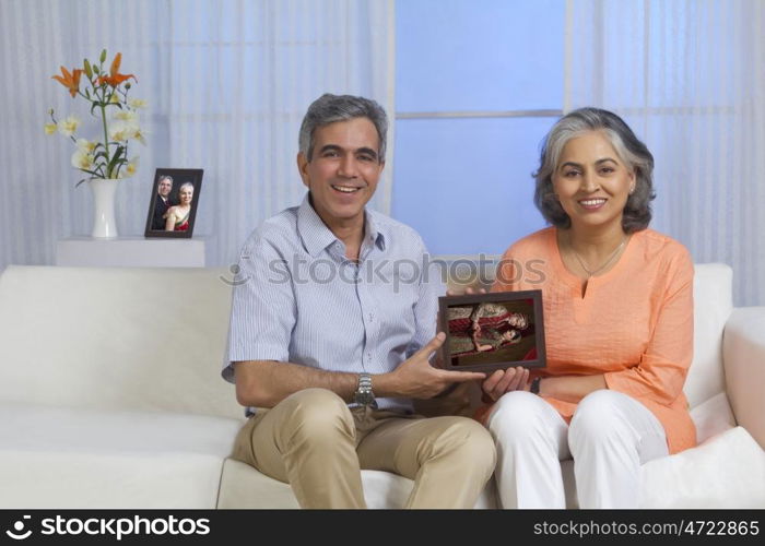 Husband and wife holding picture of their children