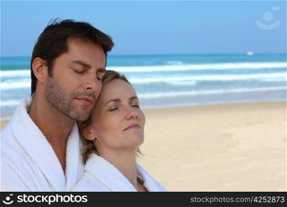 Husband and wife on the beach in bath robes