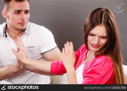 Husband apologizing wife. Upset, angry, mad woman refuses apology pushing him away. Boyfriend trying to convince girlfriend. Man asking for forgivness. Conflicted couple. Relationship problem.