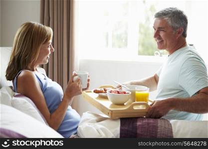 Husband Bringing Wife Breakfast In Bed On Tray