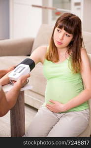 Husband checking pregnant wife&rsquo;s blood pressure