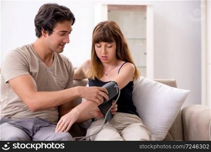 Husband checking wife&rsquo;s blood pressure