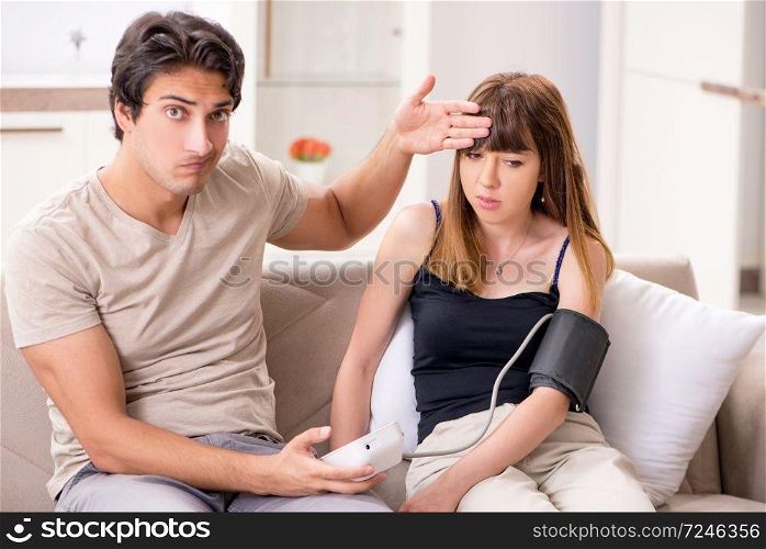 Husband checking wife&rsquo;s blood pressure