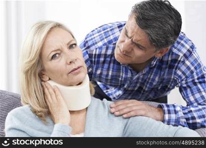 Husband Comforting Husband Suffering With Neck Injury