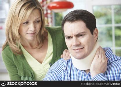 Husband Comforting Wife Suffering With Neck Injury