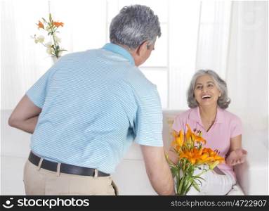 Husband giving flowers to his wife