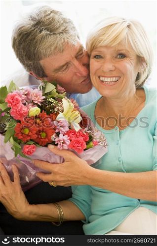 Husband giving wife flowers kissing and smiling