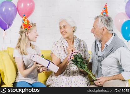 husband granddaughter giving birthday gift happy woman