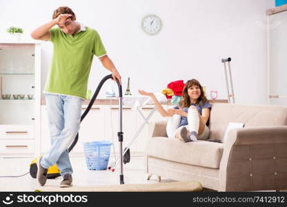 Husband helping leg injured wife in housework