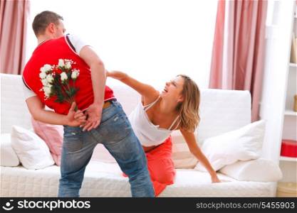 Husband hiding flowers from his curious pregnant wife&#xA;